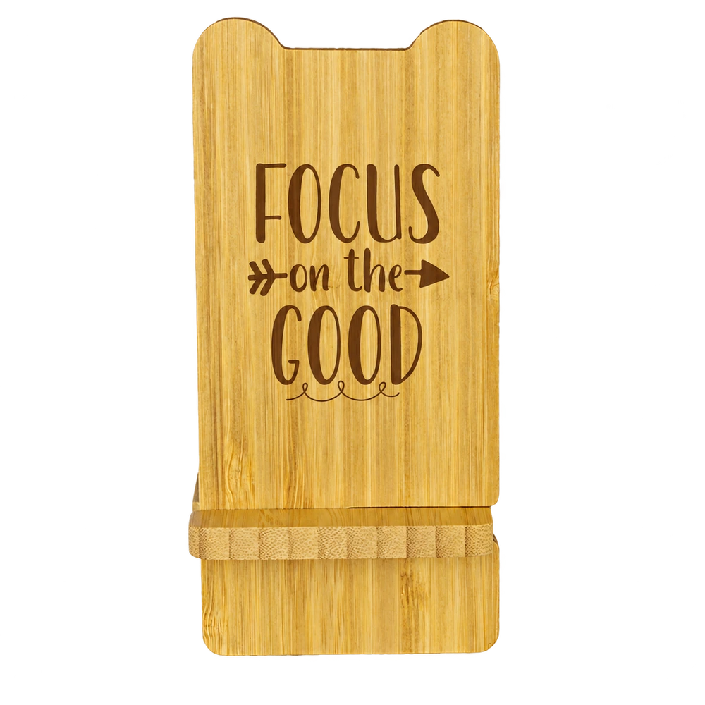 Natural bamboo Volt wireless charging phone stand with Focus on the Good sample engraving and a front support ledge.